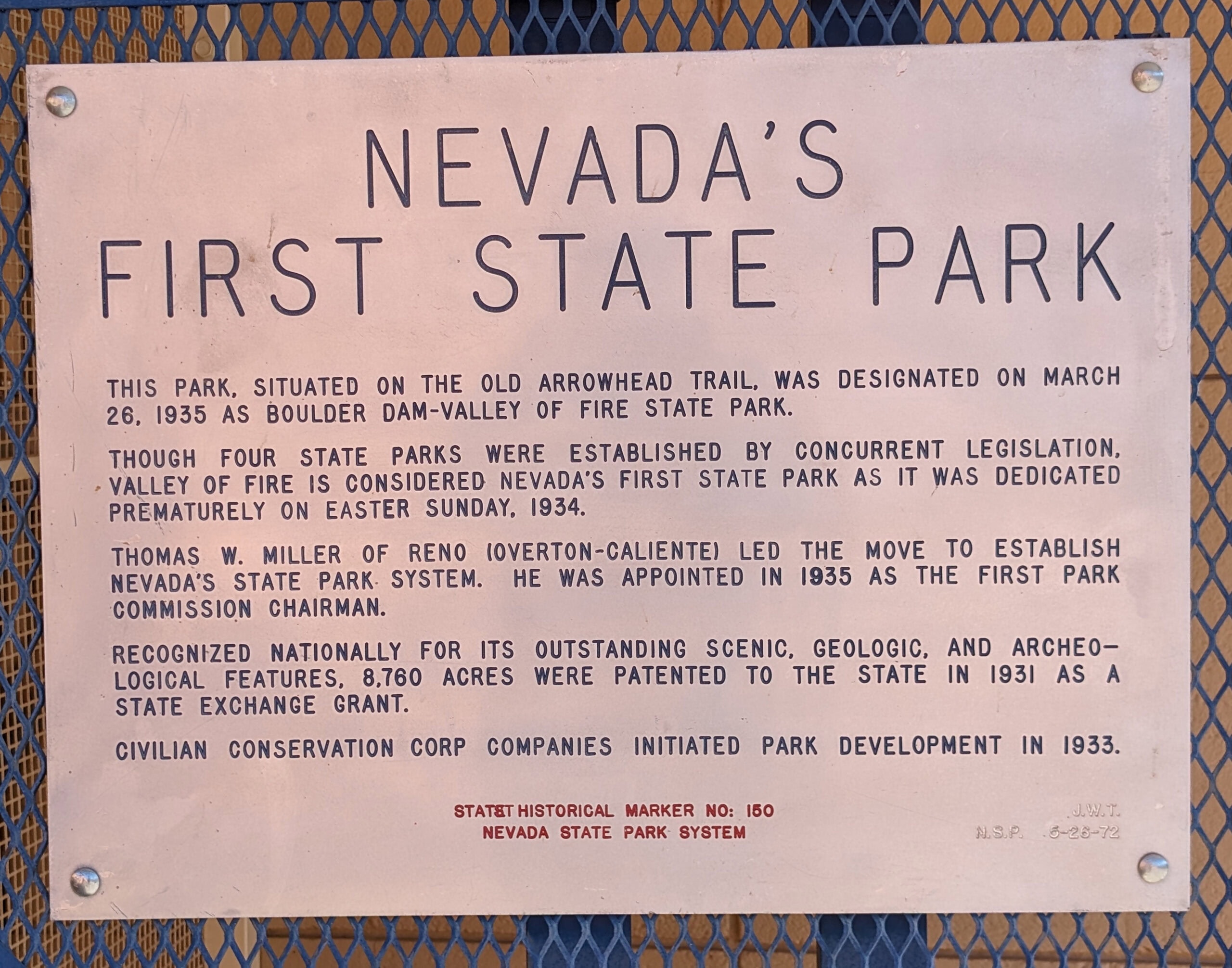 Historical marker titled “Nevada’s First State Park,” explaining the designation and early history of Valley of Fire State Park, mounted on a blue metal background.
