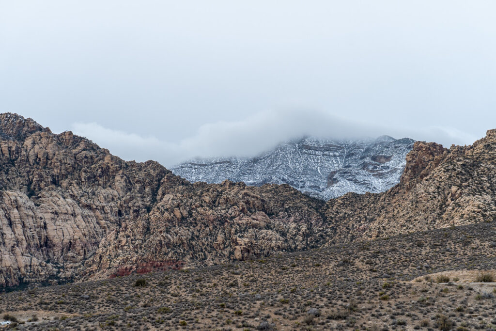Wide desert vista with dramatic red rock formations and mountains at Red Rock Canyon outside Las Vegas.
